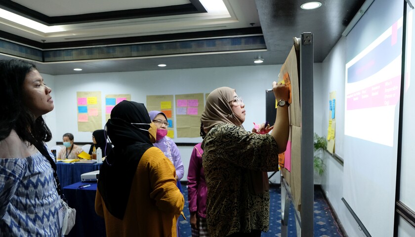 A group of women at a pinboard at the learning exchange in the Philippines